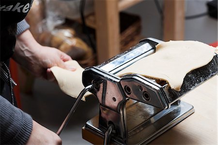 Woman Cranking Pasta Machine; Making Fresh Pasta Stock Photo - Premium Royalty-Free, Code: 659-06152341