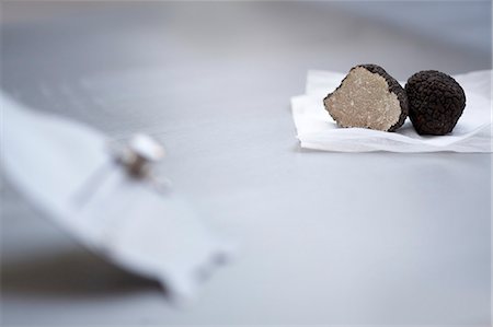 Black truffles, halved, on paper, on a truffle slice Foto de stock - Sin royalties Premium, Código: 659-06152410