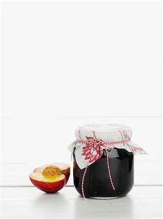 A jar of peach jam with half a peach next to it Foto de stock - Sin royalties Premium, Código: 659-06152522