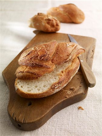 Country bread on a chopping board Stock Photo - Premium Royalty-Free, Code: 659-06152625