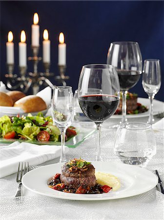 Beef medallions with vegetables, salad and red wine on a laid table Stock Photo - Premium Royalty-Free, Code: 659-06152700