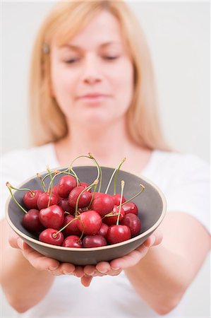 simsearch:659-06153011,k - A woman holding a bowl of cherries Foto de stock - Sin royalties Premium, Código: 659-06152898