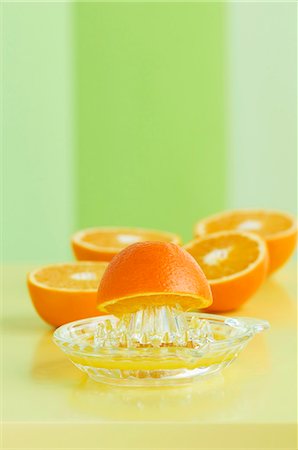 spremiagrumi a mano - Orange halves with a juicer Fotografie stock - Premium Royalty-Free, Codice: 659-06152911