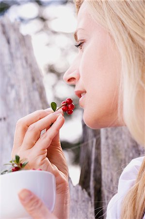 A woman eating fresh lingonberries Stock Photo - Premium Royalty-Free, Code: 659-06153018