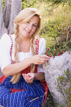 A woman in a dirndl picking lingonberries in a forest Foto de stock - Sin royalties Premium, Código: 659-06153010