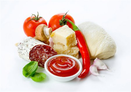 simsearch:659-06154303,k - Pizza ingredients: tomatoes, a ball of dough, parmesan, Italian salami, garlic, ketchup, mushrooms Stock Photo - Premium Royalty-Free, Code: 659-06153054