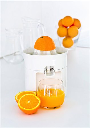 Freshly pressed orange juice with a juicer Foto de stock - Royalty Free Premium, Número: 659-06153064