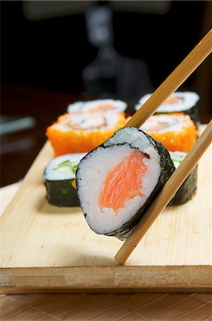 seafood food presentation - Maki sushi held in chopsticks Stock Photo - Premium Royalty-Free, Code: 659-06153101