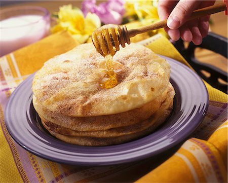 Hand Drizzling Honey Over Sopapillas (Mexican Fried Pastry) Stock Photo - Premium Royalty-Free, Code: 659-06153156