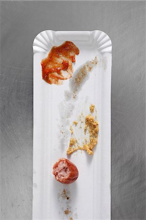 Left over sausage, ketchup and mustard on a paper plate Stock Photo - Premium Royalty-Free, Code: 659-06153314