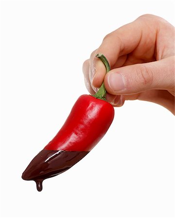 simsearch:659-03525709,k - Hand holding a chili pepper dripping with melted chocolate Foto de stock - Sin royalties Premium, Código: 659-06153351