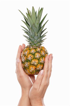 single pineapple - Hands holding a baby pineapple Stock Photo - Premium Royalty-Free, Code: 659-06153362