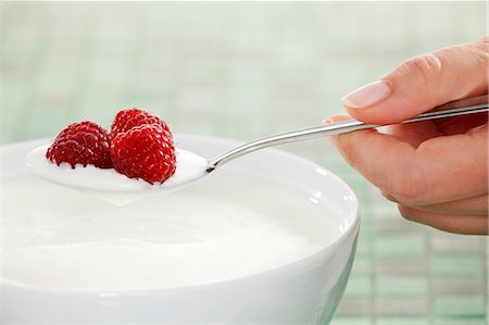 soft fruit yogurt - Hand holding a spoon of yogurt with raspberries Stock Photo - Premium Royalty-Free, Code: 659-06153370