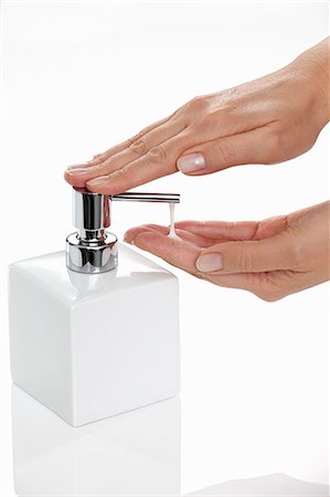 Liquid soap being pumped out of a soap dispenser Stock Photo - Premium Royalty-Free, Code: 659-06153373