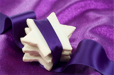 pasteles de navidad - Stacked cinnamon stars wrapped with purple ribbon Foto de stock - Sin royalties Premium, Código: 659-06153630