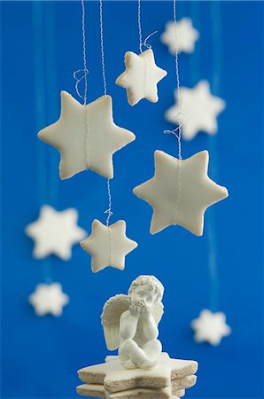 Cinnamon stars hanging above a seated angel figurine Foto de stock - Sin royalties Premium, Código: 659-06153633