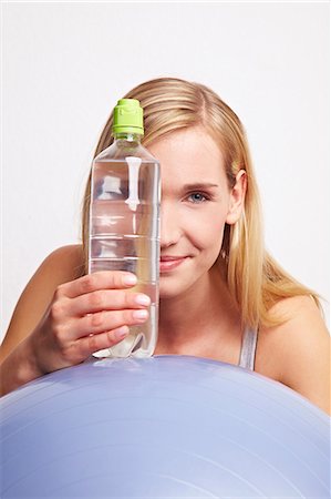 Une jeune femme avec une balle de gymnastique et une bouteille d'eau minérale Photographie de stock - Premium Libres de Droits, Code: 659-06184003