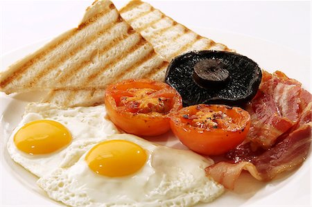 Petit déjeuner anglais avec oeuf au plat, bacon, tomates, champignons et toast Photographie de stock - Premium Libres de Droits, Code: 659-06184072