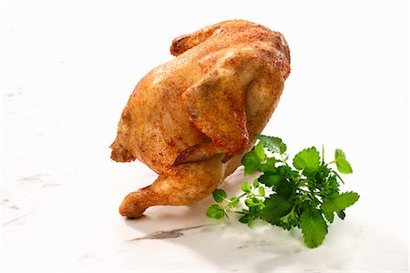 Un poulet rôti entier et herbes fraîches Photographie de stock - Premium Libres de Droits, Code: 659-06184096