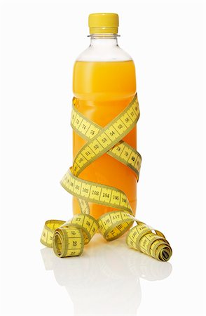 A bottle of orange juice with a tape measure Stock Photo - Premium Royalty-Free, Code: 659-06184148