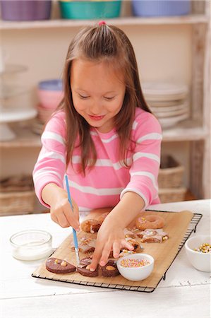 decor chic - A girl decorating biscuits with icing sugar Foto de stock - Sin royalties Premium, Código: 659-06184212