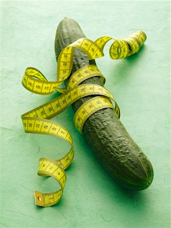 slim - A cucumber with tape measure on a green surface Stock Photo - Premium Royalty-Free, Code: 659-06184396