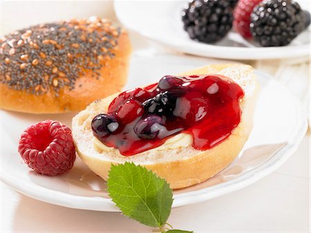 simsearch:659-06903115,k - A bread roll spread with butter and berry jam Foto de stock - Royalty Free Premium, Número: 659-06184961