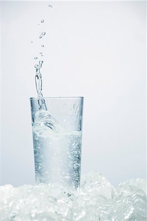 Ice cube falling into glass of ouzo Stock Photo - Premium Royalty-Free, Code: 659-06185476