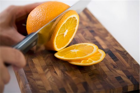 simsearch:659-06185085,k - Slicing an orange Stock Photo - Premium Royalty-Free, Code: 659-06185496