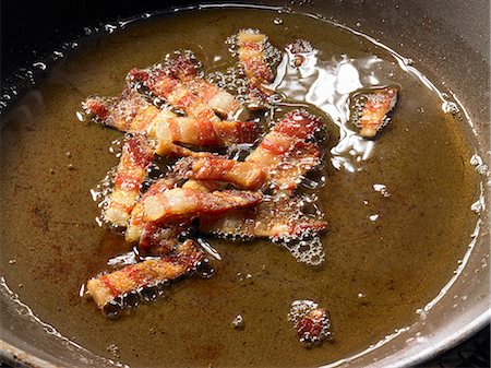 sauteeing - Frying pancetta (cured pork belly) in oil Foto de stock - Sin royalties Premium, Código: 659-06185509