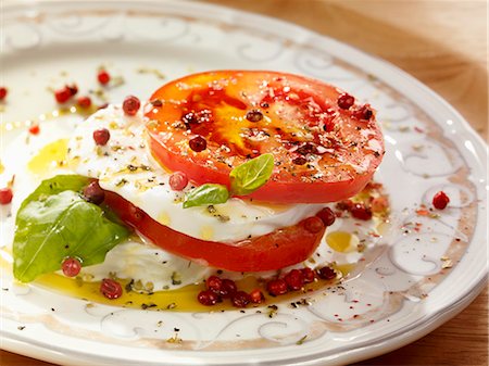 Tomatoes with mozzarella, basil, olive oil and pink peppercorns Stock Photo - Premium Royalty-Free, Code: 659-06185517