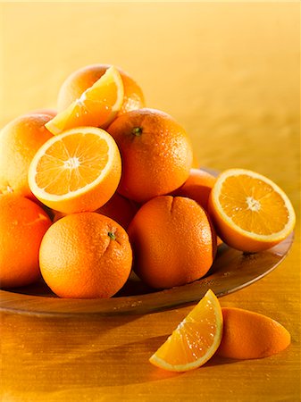 fruit of orange color - Oranges, whole and halved, in a wooden bowl Stock Photo - Premium Royalty-Free, Code: 659-06185593