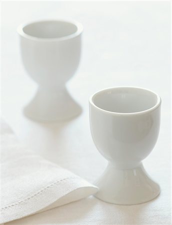 Two White Egg Cups with a White Napkin Foto de stock - Sin royalties Premium, Código: 659-06185672