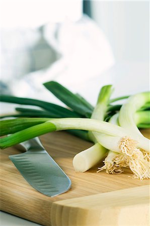 Spring onions and a knife on a wooden board Stock Photo - Premium Royalty-Free, Code: 659-06186023