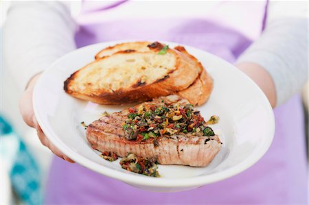 steak on grill - A person holding a plate of steak and bread Stock Photo - Premium Royalty-Free, Code: 659-06186385