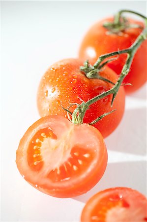 Organic Vine Ripened Tomatoes with Vine; One Halved Stock Photo - Premium Royalty-Free, Code: 659-06186421