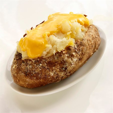 fundición - Baked Potato with Salt and Melted Cheese; On a White Plate on a White Background Foto de stock - Sin royalties Premium, Código: 659-06186487