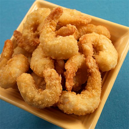 shrimp recipes - Battered Fried Shrimp in a Yellow Bowl on a Blue Background Stock Photo - Premium Royalty-Free, Code: 659-06186489