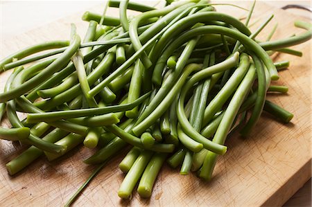 Garlic Scapes; The Green Part of the Garlic Plant; On Cutting Board Stock Photo - Premium Royalty-Free, Code: 659-06186516