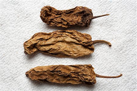 pimiento chipotle - Three Whole Dried Chipotle Peppers; From Above Foto de stock - Sin royalties Premium, Código: 659-06186517