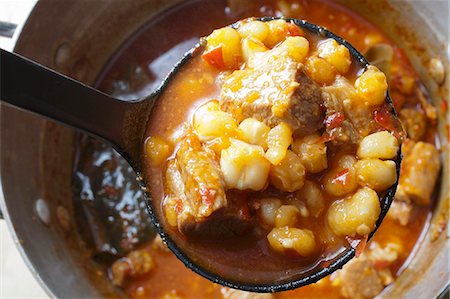 stewed - Red Posole; Mexican Hominy Stew; Made with Pork; In Ladle Above Pot Foto de stock - Sin royalties Premium, Código: 659-06186530