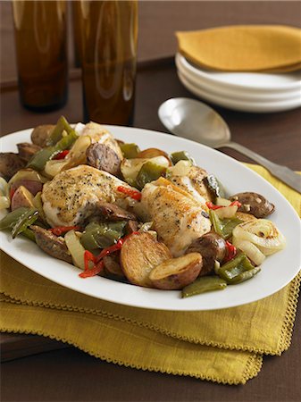 Roasted Chicken Thighs with New Potatoes, Onions and Peppers on a Serving Dish Stock Photo - Premium Royalty-Free, Code: 659-06186603