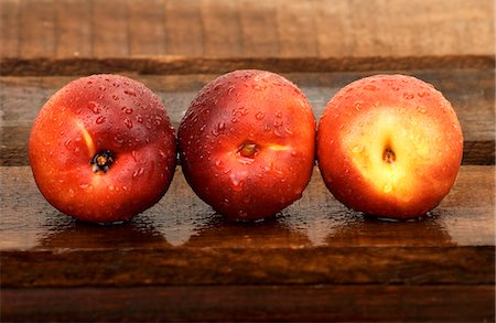 simsearch:859-06470140,k - Three nectarines with droplets of water on wooden crate Fotografie stock - Premium Royalty-Free, Codice: 659-06186630