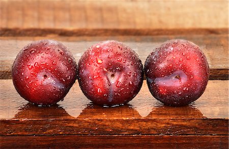 simsearch:659-07597303,k - Three plums with droplets of water on wooden crate Foto de stock - Sin royalties Premium, Código: 659-06186632