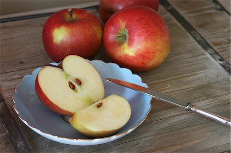 pomiferous fruit - Red apples, a fruit knife, an apple half and a quarter Stock Photo - Premium Royalty-Free, Code: 659-06186736