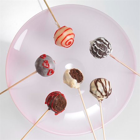 simsearch:659-06373902,k - Cake pops with chocolate icing and red writing icing, one with a bite taken out Foto de stock - Sin royalties Premium, Código: 659-06186746