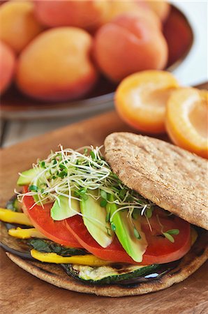 simsearch:659-06152627,k - Veggie Sandwich with Grilled Eggplant, Zucchini, Yellow Peppers, Tomato and Avocado on a Flat Round Roll Fotografie stock - Premium Royalty-Free, Codice: 659-06186797