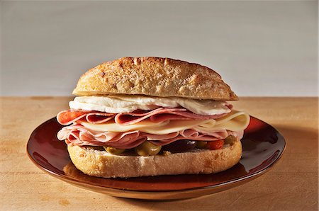Muffaletta Sandwich with Ham, Mortadella, Provolone, Mozzarella, Genoa Salami and Olive Spread Stock Photo - Premium Royalty-Free, Code: 659-06186792