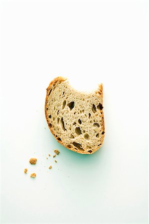A piece of rye bread with a bite taken out Stock Photo - Premium Royalty-Free, Code: 659-06186852