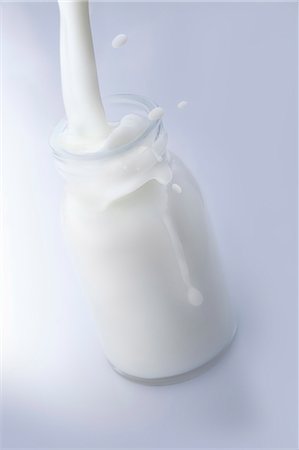 simsearch:659-08940852,k - Milk being poured into a bottle Foto de stock - Sin royalties Premium, Código: 659-06186950